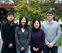 Asian male postdoc, two Asian female faculty members, and white male grad student collaborators standing outdoors and smiling.