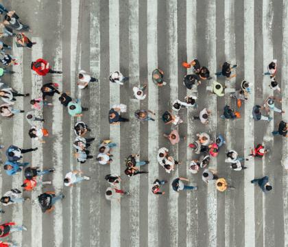 People crossing a busy intersection. 